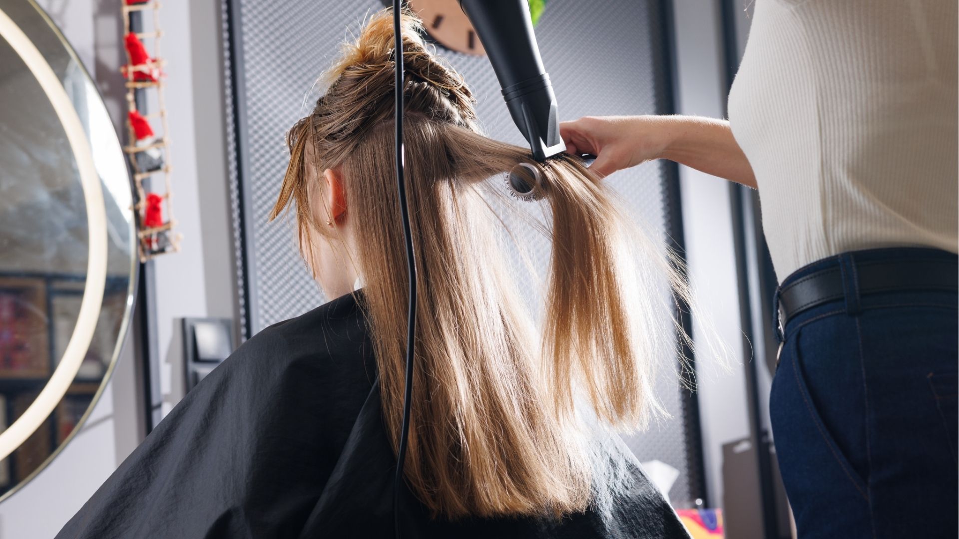 Coiffeuse réalisant un brushing sur cheveux longs
