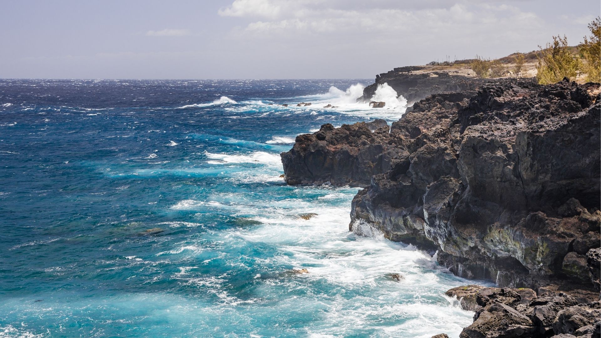 Falaises volcaniques et vagues sur le littoral de L’Étang-Salé