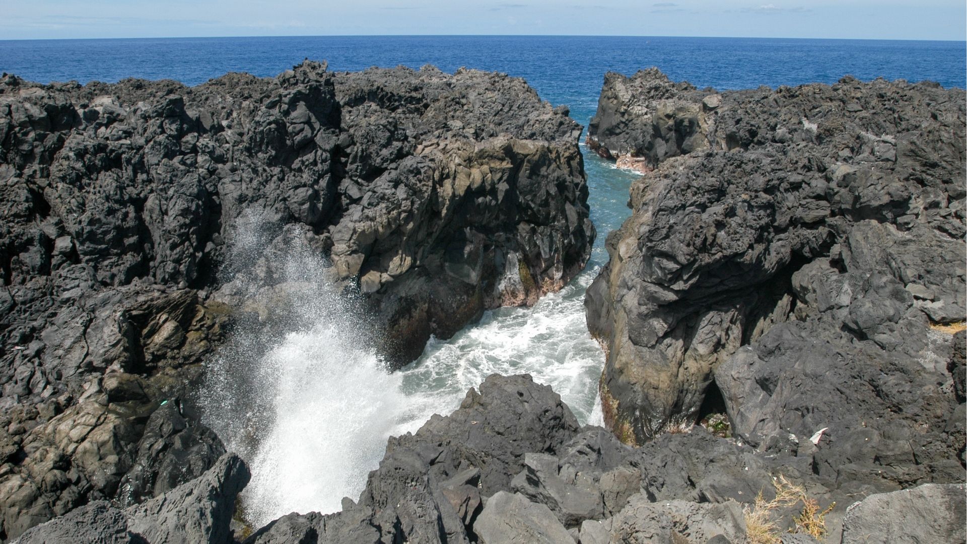 Le Gouffre de L’Étang-Salé avec ses roches volcaniques et les vagues