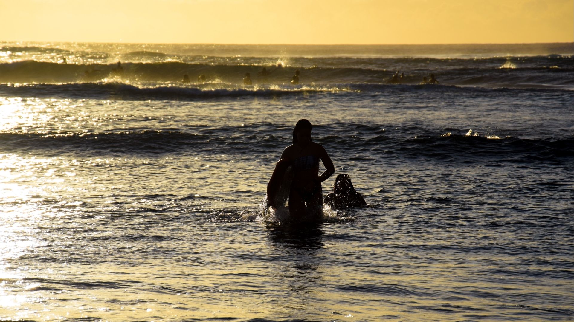 Baigneurs dans l’océan au coucher du soleil à Saint-Leu à La Réunion