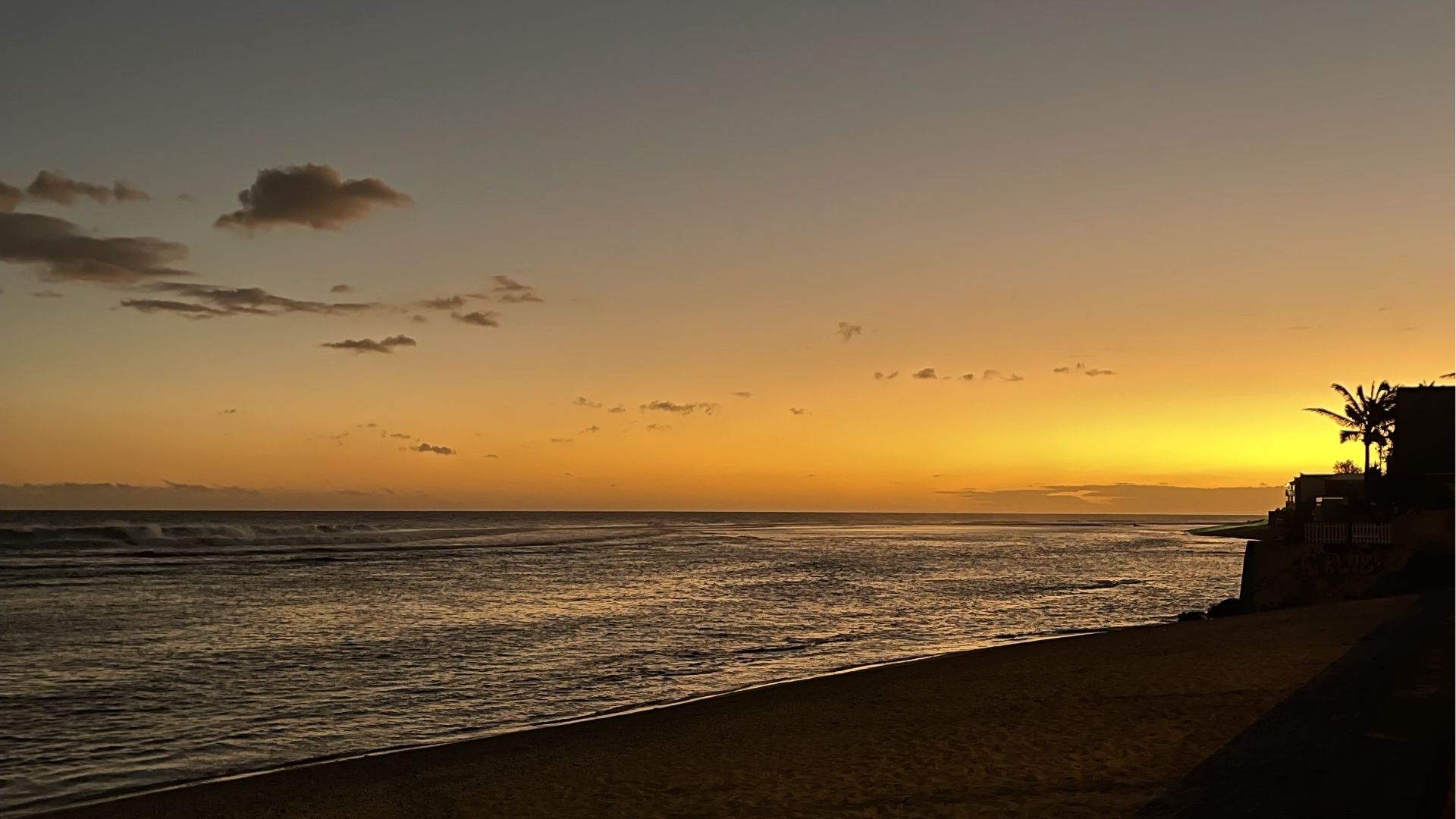 Coucher de soleil sur la plage de Saint-Pierre avec le ciel orangé et l’océan à La Réunion