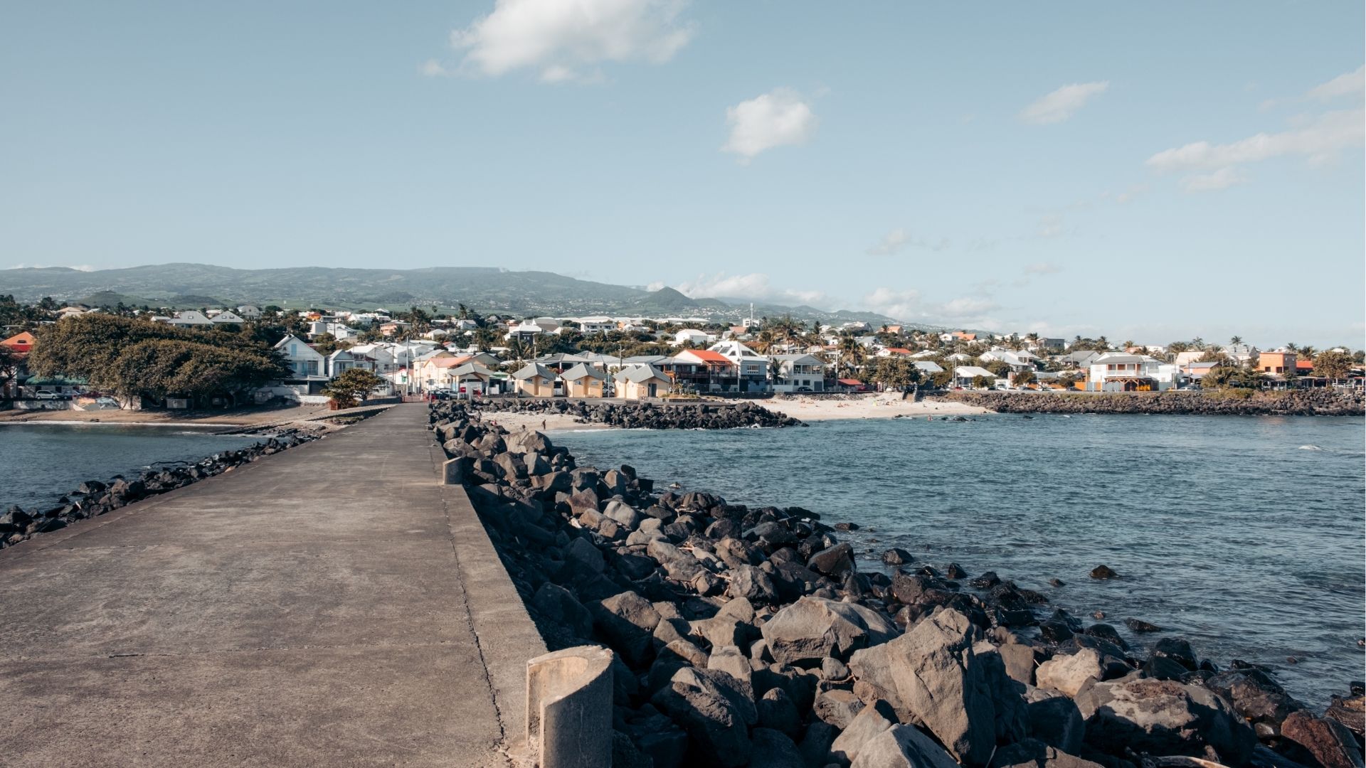 Vue depuis la jetée du front de mer de Saint-Pierre avec les maisons et les montagnes en arrière-plan à La Réunion