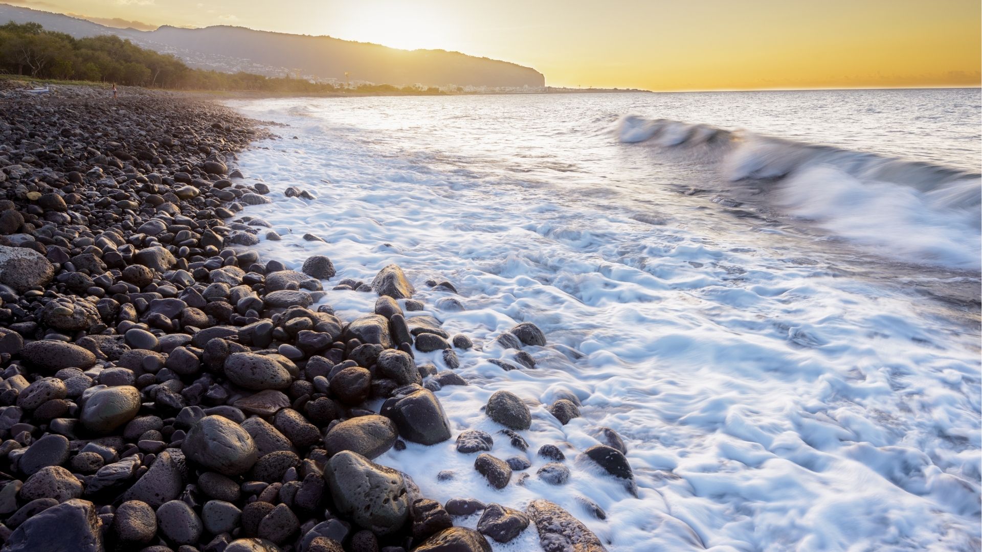 plage de galets à Saint-Denis au coucher du soleil