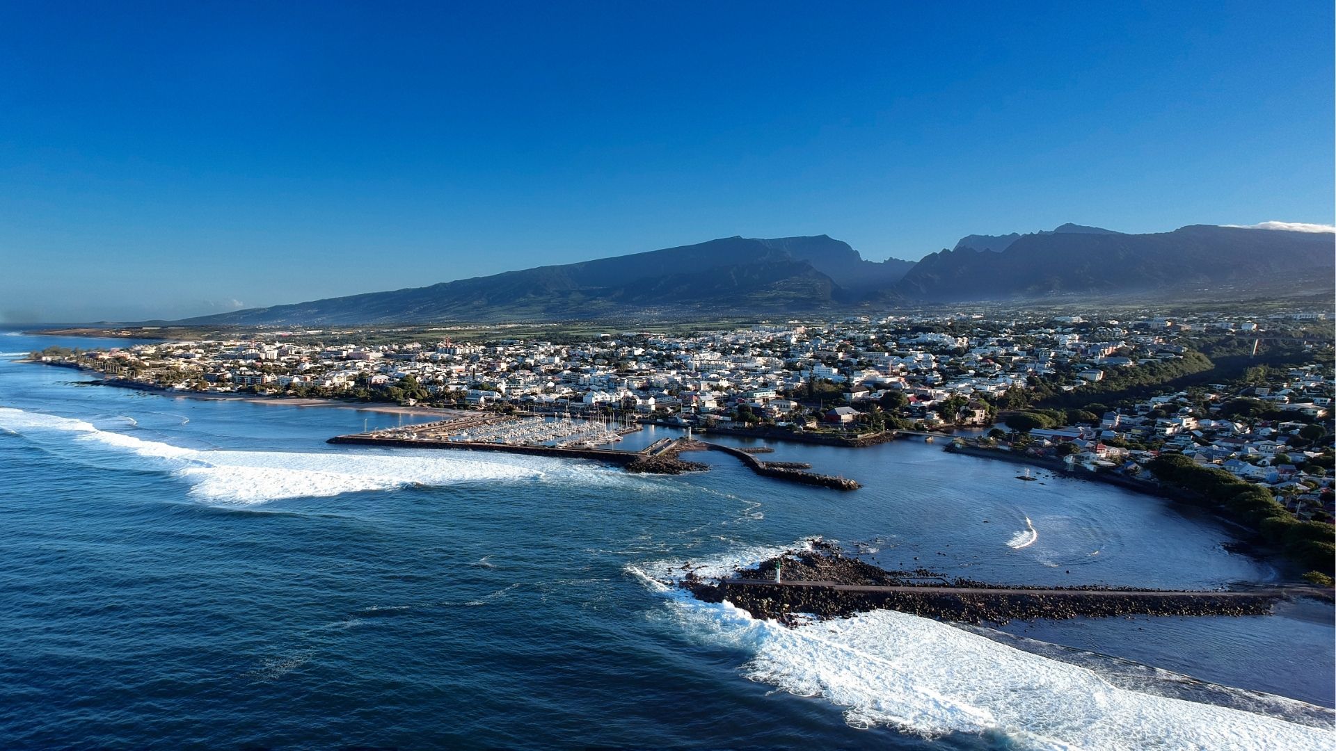 vue aérienne du littoral de Saint-Pierre avec le port, les vagues et les montagnes en arrière-plan à La Réunion