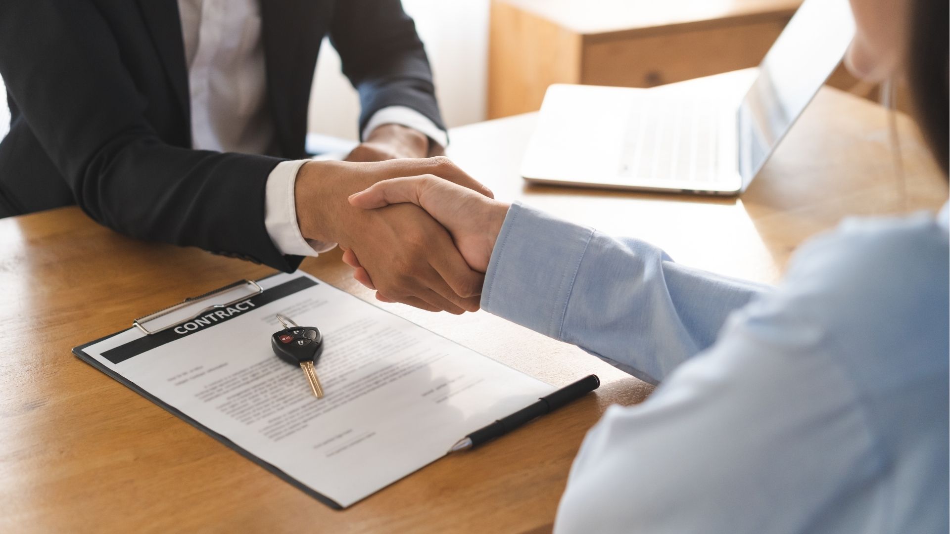 poignée de main lors de la signature d’un contrat de location de voiture